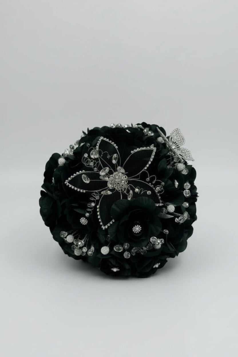 dark green  flower arrangement with silver embellishments on a white background