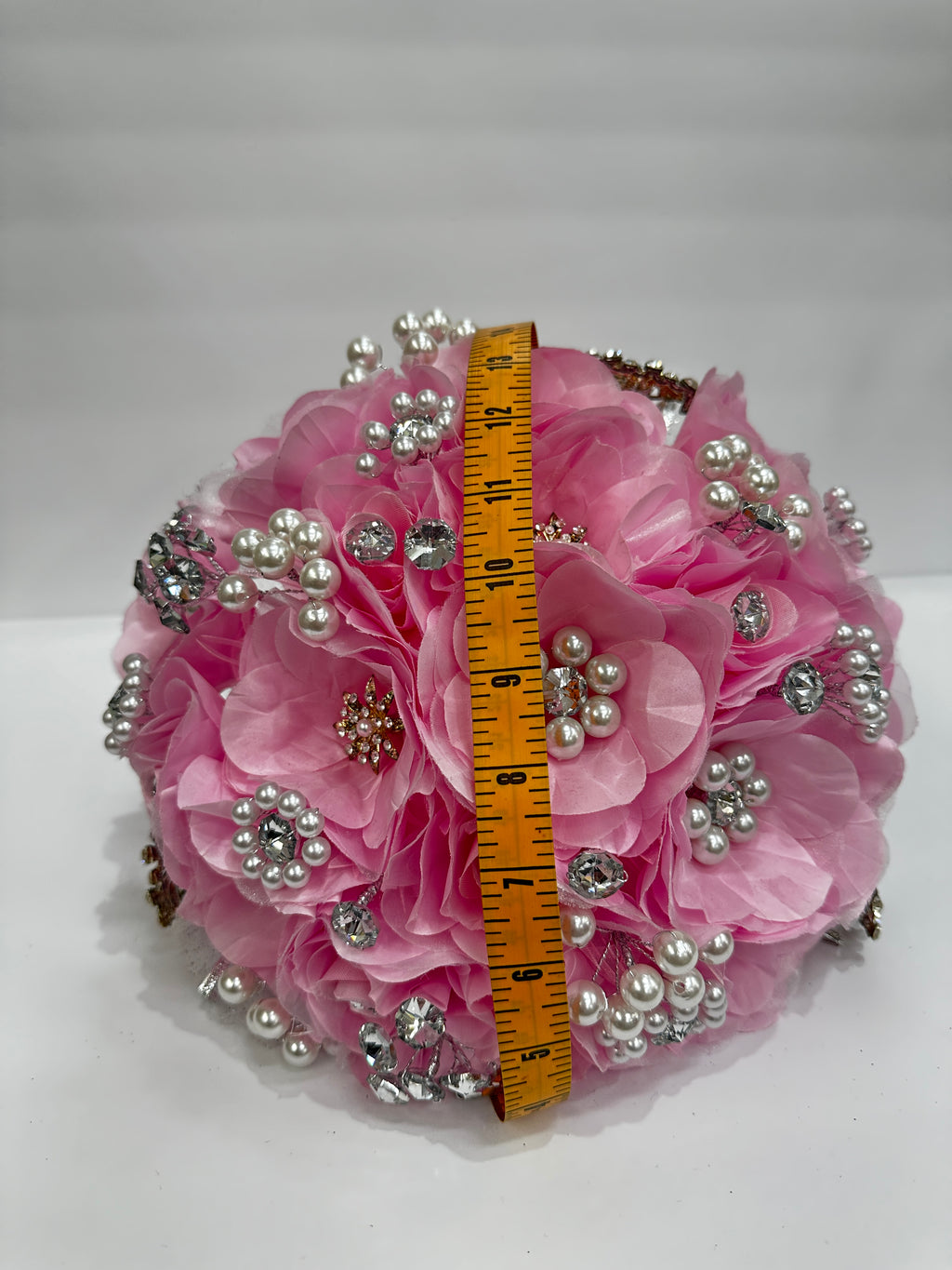 Pink bouquet  with pearls and a measuring tape for hemeisphere scale about 14inches  on a white background